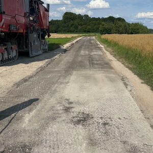 Fahrradweg, der gerade saniert wird. Auf der linken Seite ein Baustellenfahrzeug