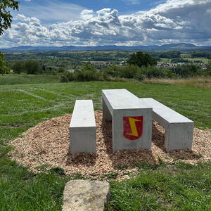 Zwei Sitzbänke und ein Tisch aus Beton mit Blick auf den Albtrauf