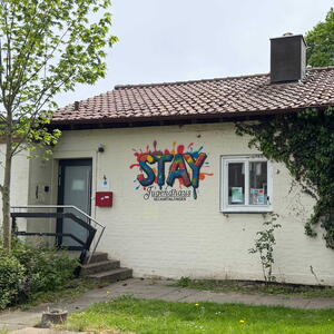Eingang zu einem Jugendhaus mit der Aufschrift "STAY"