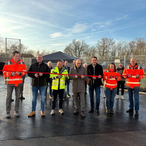 Einweihung eines neues Recyclinghofs in Neckartailfingen. Mehrere Menschen durchschneiden ein rotes Band.